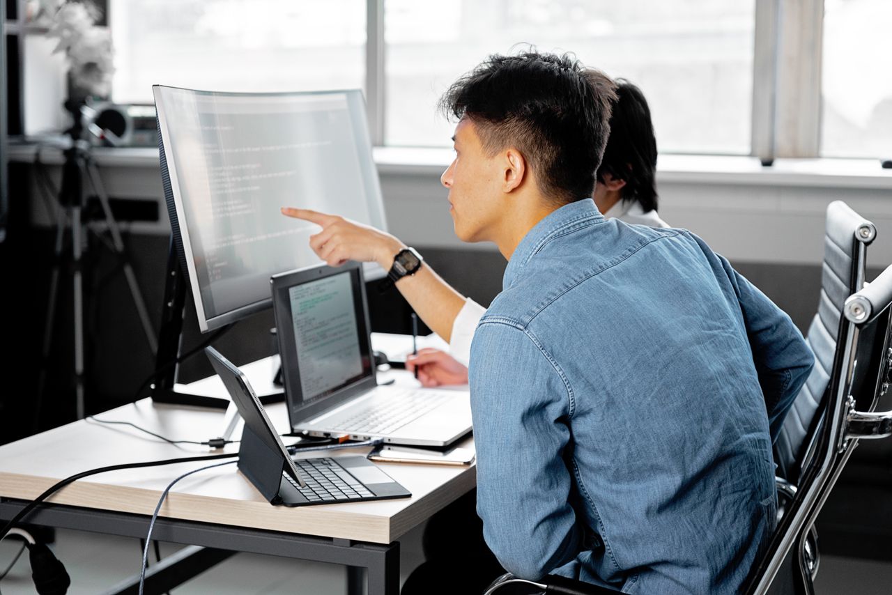 Mastering the First Impression: Your intriguing post title goes here Professionals collaborating at a tech-centric workspace with laptops and monitors.